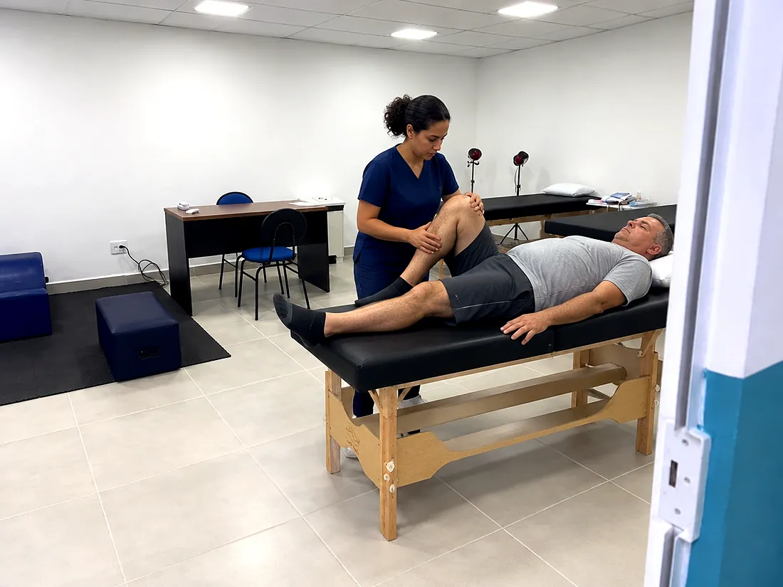 Fisioterapeuta atendendo um paciente na sala de reabilitação da clínica (imagem ilustrativa)