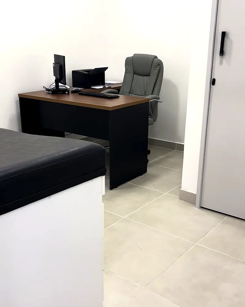 Consultório da unidade do KM 32, com mesa de atendimento e maca